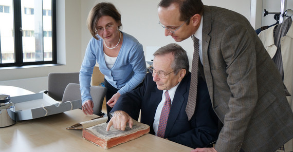 Foto: Anke Geißler-Grünberg (Universitätsbibliothek) mit Berl und David Schor. Foto: Bastian Wiesemann. Drei Personen schauen zusammen in ein 500 Jahre altes Buch.