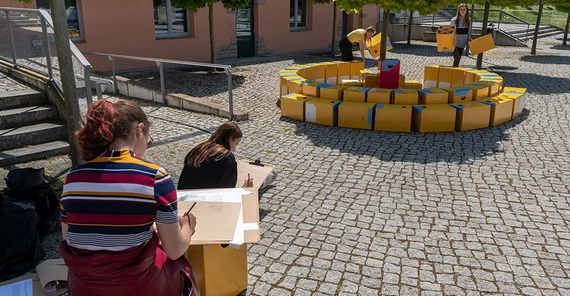 In drei Gruppen verbauen sie Pappwürfel der Bundesstiftung Baukultur.