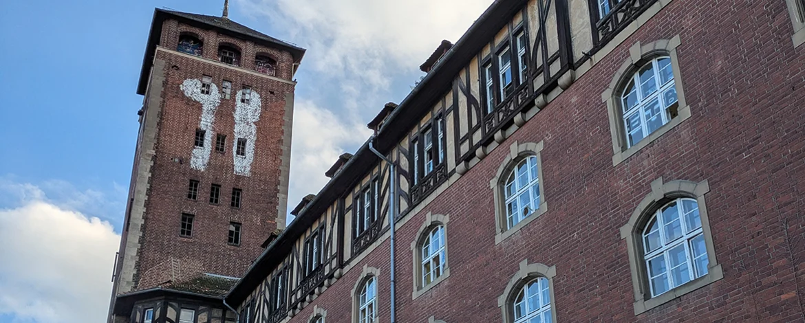 A large red-brick house with a tower. - 