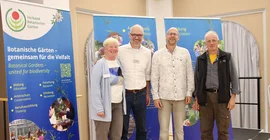 Vier Personen posieren für ein Gruppenbild.