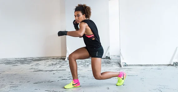 Marie Mouroum in geducktem Ausfallschritt. Arme in Boxhaltung erhoben.