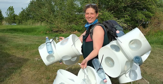 Eine mit Reusen beladene Person auf dem Weg zu den untersuchungsflächen.