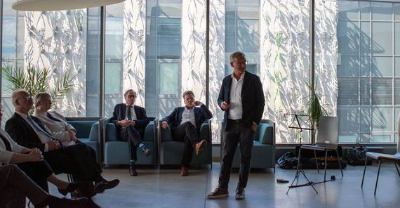 Ein Mann spricht vor anderen bei einer Veranstaltung