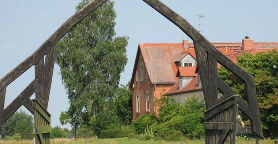 Ökologische Station Gülpe / Foto: Ralf-Udo Mühle Natur mit einem Haus, einem Holzbogen und einem Storch