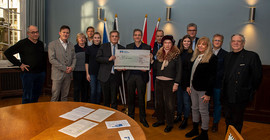 Potsdams Oberbürgermeister Mike Schubert und der Vizepräsident für Internationales und Fundraising der Universität Potsdam Prof. Dr. Florian Schweigert mit Vertreterinnen und Vertretern der Potsdamer Serviceclubs bei der Scheckübergabe am 12. Dezember im Stadthaus.