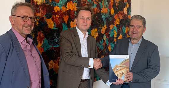 Profe Professor Joachim Ludwig (l.) und Professor Gisbert Fanselow (r.) übergeben die von 260 Beschäftigten unterzeichnete Selbstverpflichtung zum Verzicht auf dienstliche Kurzstreckenfüge an den Präsidenten der Universität, Prof. Oliver Günther, Ph.D. (Foto: Universität Potsdam/Horn-Conrad).