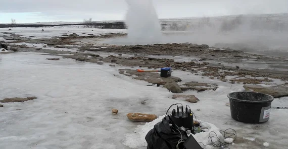 Eruption des Strokkur Geysir von Westen am 12.3.2020 mit aufzeichnendem blueSeis-3A Rotationssensor (schwarz) und Trillium Compact Seismometer (grün) im Vordergrund. Der im Sommer für Touristen frei gegebene Weg ist vereist. | Foto: Eva Eibl