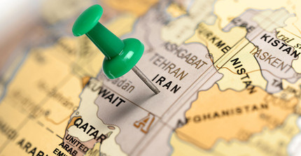 Landkarte auf der der Iran mit einer Reisszwecke markiert ist.