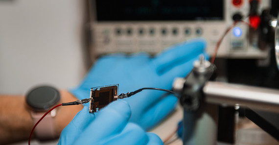 Two hands holding a component for a solar cell