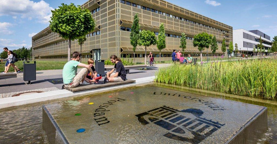 Studierende vor dem „Goldenen Käfig“ (Haus 28), Sitz des Instituts für Physik und Astronomie, auf dem Universitätscampus Potsdam-Golm. Foto: Thomas Roese. Studierende vor dem „Goldenen Käfig“ (Haus 28), Sitz des Instituts für Physik und Astronomie, auf dem Universitätscampus Potsdam-Golm. Foto: Thomas Roese.