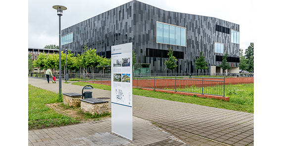 Die Informationstafel am Campus Golm (Foto: Karla Fritze) Vorn die Informationstafel, im Hintergrund der schwarze Kubus der Bibliothek