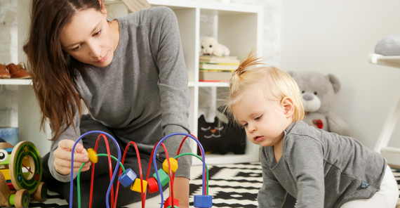 "Familie ist immer noch eine Angelegenheit des Privaten" | Foto: AdobeStock/triocean Eine Mutter sitzt mit einem Kleinkind und einem Spielzeug auf dem Boden. Das Foto ist von AdobeStock/triocean.