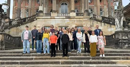 Gruppenfoto der neuen Auszubildenden und Ausbildungsleitung auf den Treppen an den Communs am Neuen Palais.