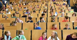 Kinder in einem Hörsaal während einer Vorlesung
