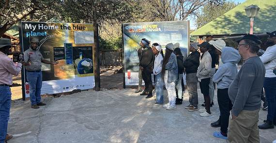Menschen stehen vor einem Plakat, während einer es erklärt