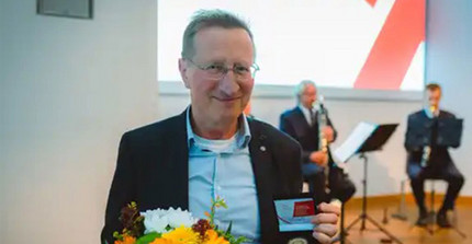 Prof. Dr. Wilfried Schubarth mit Blumenstrauß und Medaille.