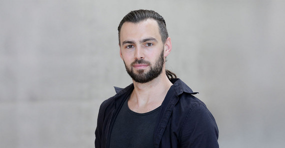 Steffen Hagemann im Porträt vor einer grauen Betonwand am Campus Griebnitzsee.