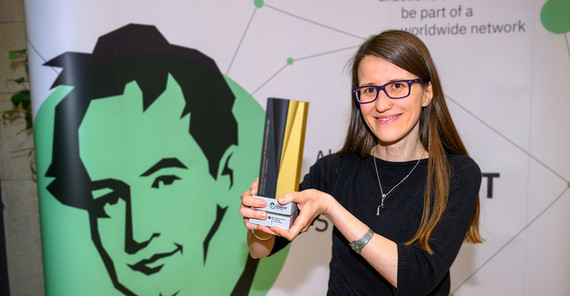 Porträt einer Frau, die einen Preis in die Höhe hält