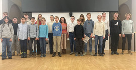 Kinder verschiedener Altersgruppen posieren für ein Gruppenfoto.