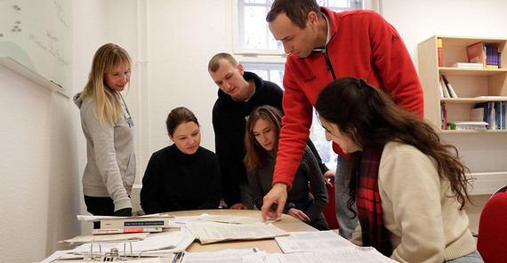 Das Team vom Projekt „TubeWork“ sitzen zusammen am Schreibtisch und diskutieren über Ergebnisse ihrer Arbeit.
