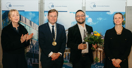 Vier Menschen stehen bei einer Preisverleihung zusammen