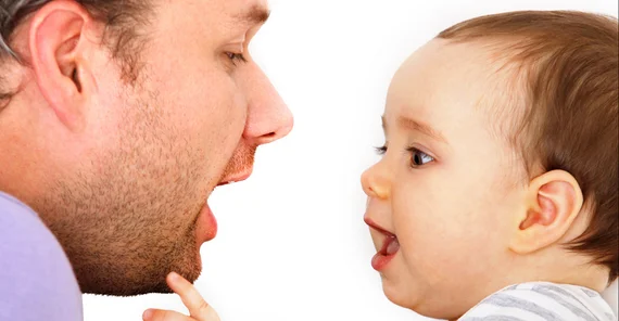 Vater und Baby lachen. Kind imitiert den Vater.