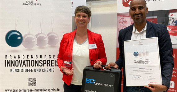 Dr. Franziska Pruin von der UP Transfer GmbH und Prof. Dr. Amitabh Banerji mit dem Experimentierkoffer bei der Preisverleihung in Cottbus | Foto: Christoph Blase Dr. Franziska Pruin von der UP Transfer GmbH und Prof. Dr. Amitabh Banerji mit dem Experimentierkoffer bei der Preisverleihung in Cottbus. Das Foto ist von Christoph Blase.