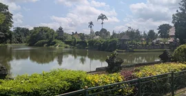 Taman-Ayun-Tempel, malerische Szenerie am Wasser, Palmen und blauer Himmel