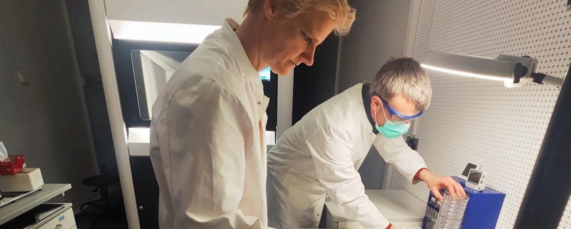 Two people preparing the sample holder for cryo-electron microscopy. - 