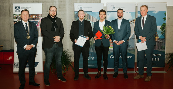 Sechs Personen stehen in einem Hörsaal bei einer Preisverleihung nebeneinander