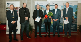 Sechs Personen stehen in einem Hörsaal bei einer Preisverleihung nebeneinander