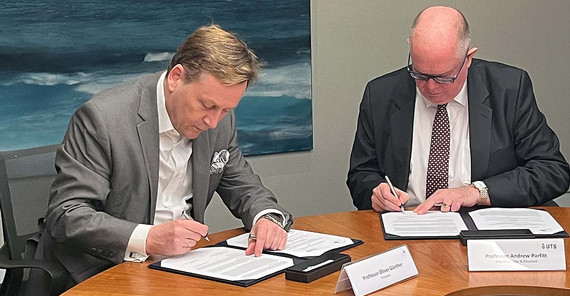 Foto von zwei Männern, die einen gemeinsamen Vertrag unterschreiben