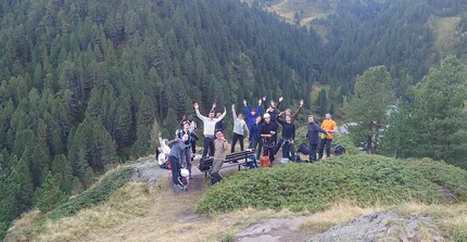 A group photo. People are waving and giving the peace sign.
