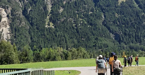 Menschen vor beeindruckender Berglandschaft.