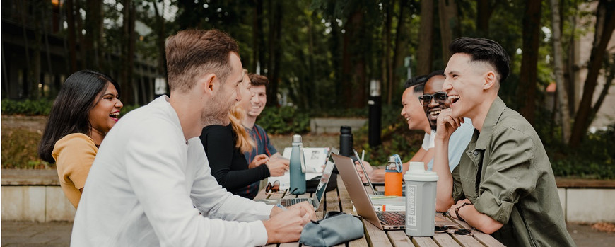 colleagues sitting outside on campus