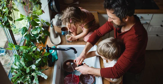 Man with two children in the kitchen.