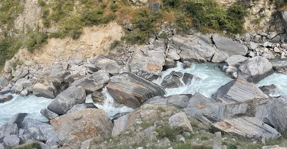 Felsbrocken an den steileren Hängen des Flusslaufs.
