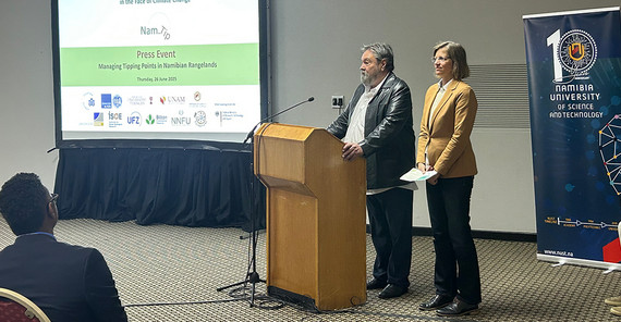 A man and a woman standing together at a speaker's desk.