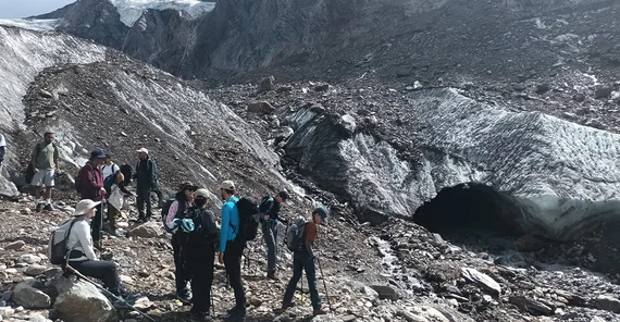 Menschen stehen vor einer torartigen Formation in einem Gletscher