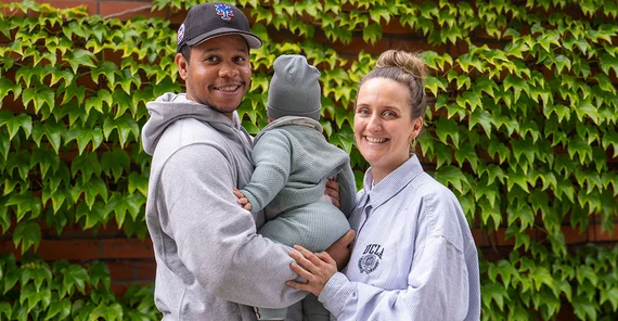 Zwei erwachsene Personen und ein Baby.