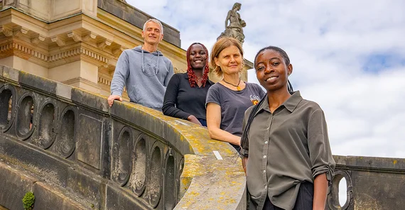 Vier Personen posieren für ein Foto auf einer Treppe.